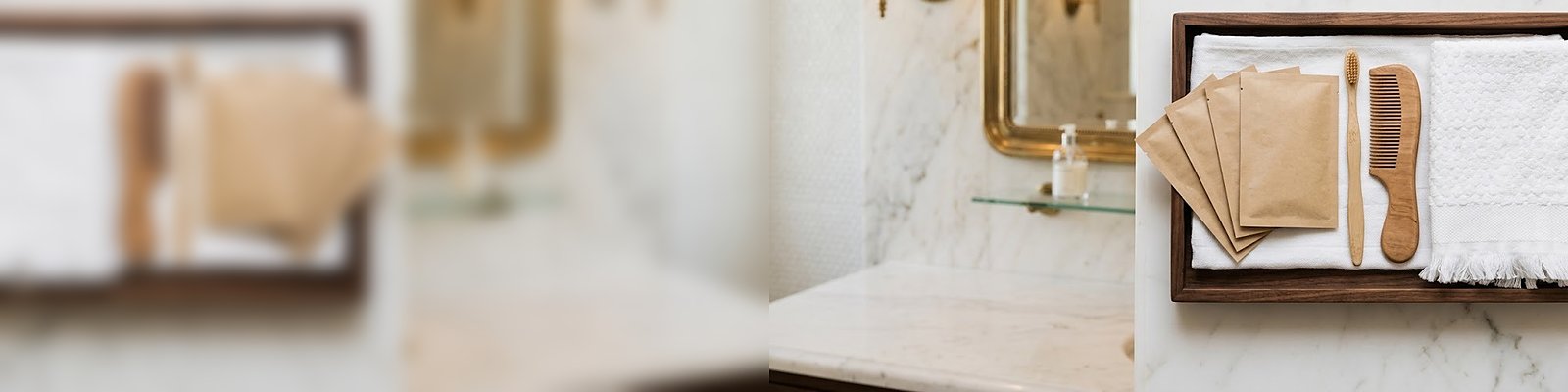 Plateau d'accueil avec sachets papier, peigne en bois et brosse à dents en bambou sur la vasque en marbre d'une suite